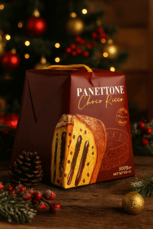 Opakowanie świątecznego panettone o smaku czekoladowym „Panettone Choco Ricco” ustawione na drewnianym stole, w tle choinka z ozdobami i świąteczne dekoracje.